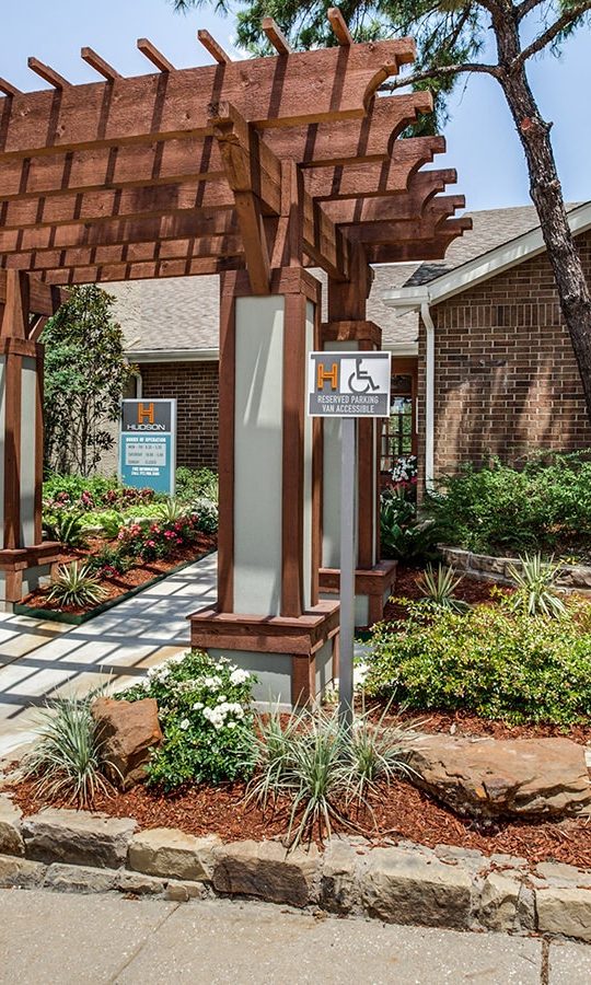 the front entrance to a home with landscaping and a pergol at The Hudson