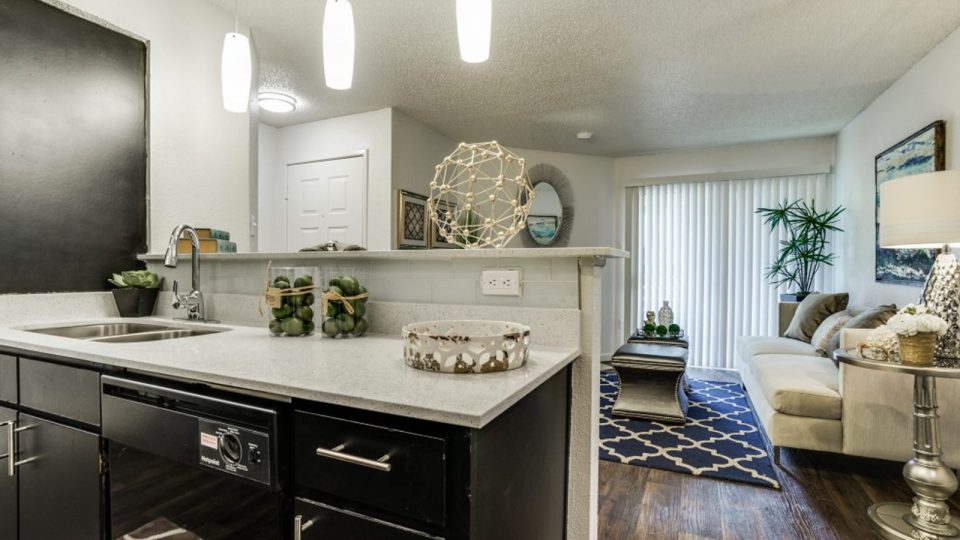 a kitchen with a black counter top and black cabinets at The Hudson